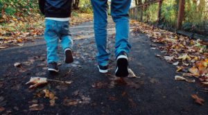 Adult and child feet and legs walking on a road