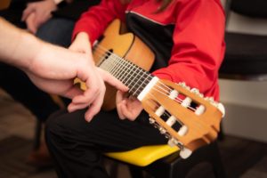 childs hands playing guitar